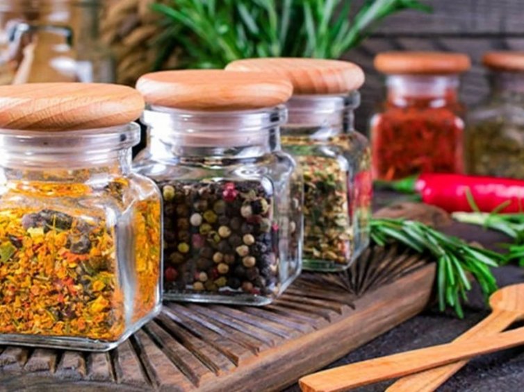 Spezie macinate etichettate e ben conservate in barattoli su uno scaffale