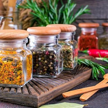 Spezie macinate in contenitori etichettati su uno scaffale in cucina